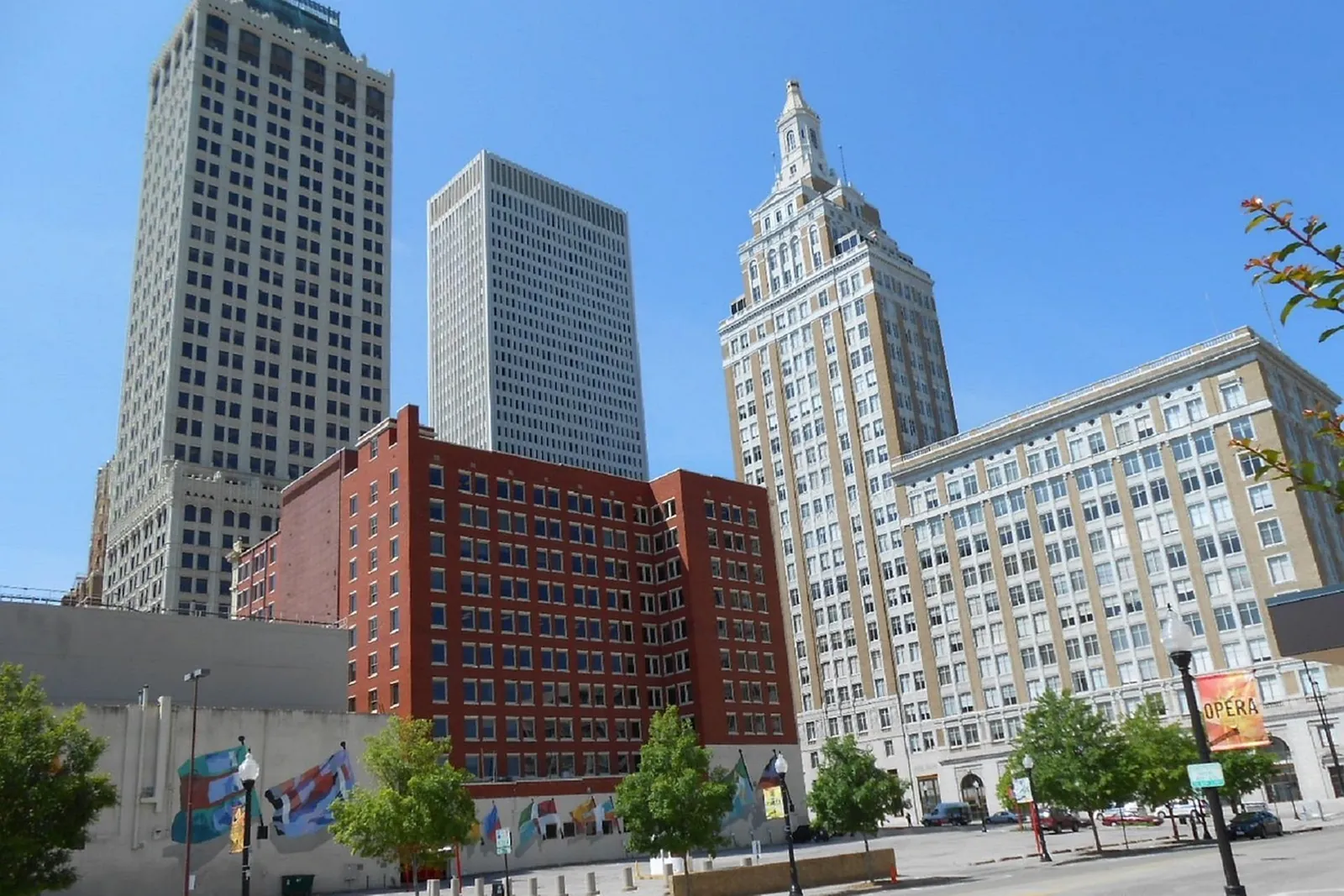Brick city buildings and geometric towers under a blue evening sky